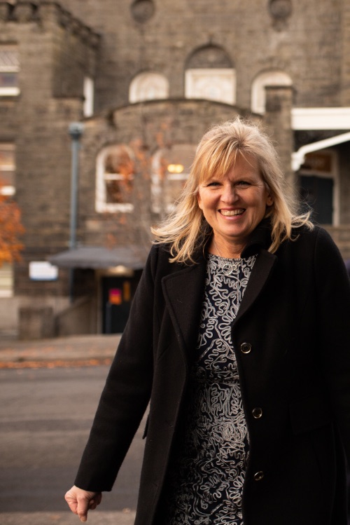 Robin Mounce smiling outdoors in a dark coat